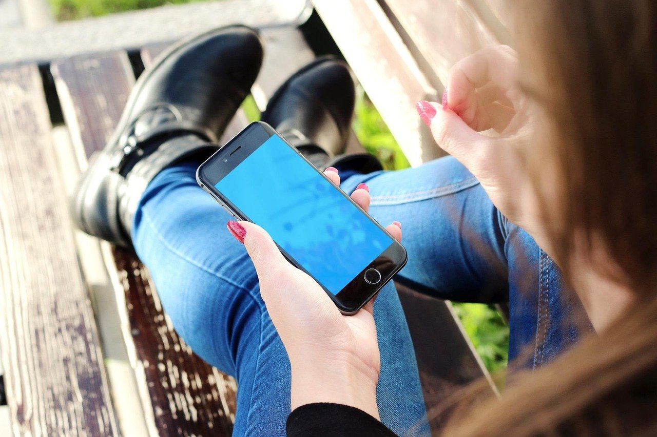 Close-up of hands holding a smartphone with its screen lit