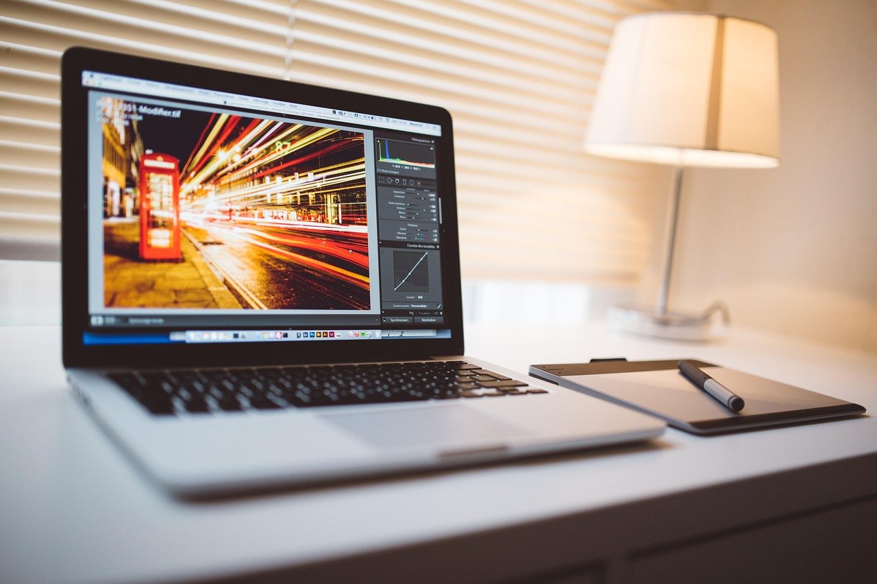 Laptop on a desk with photo editing software open